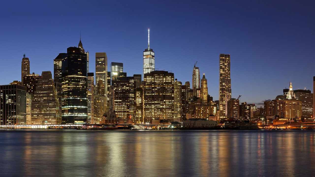 Wide panorama of the Lower Manhattan skyline across the East River, viewed from Brooklyn Bridge Park in New York City